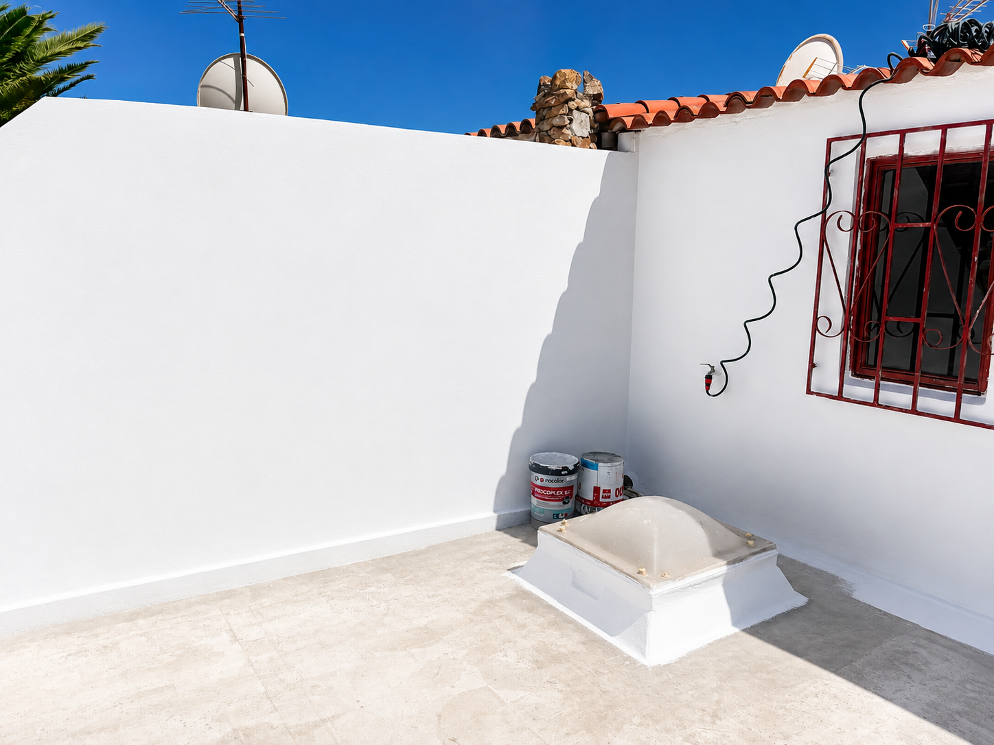 Terraza y muros exteriores pintados en blanco